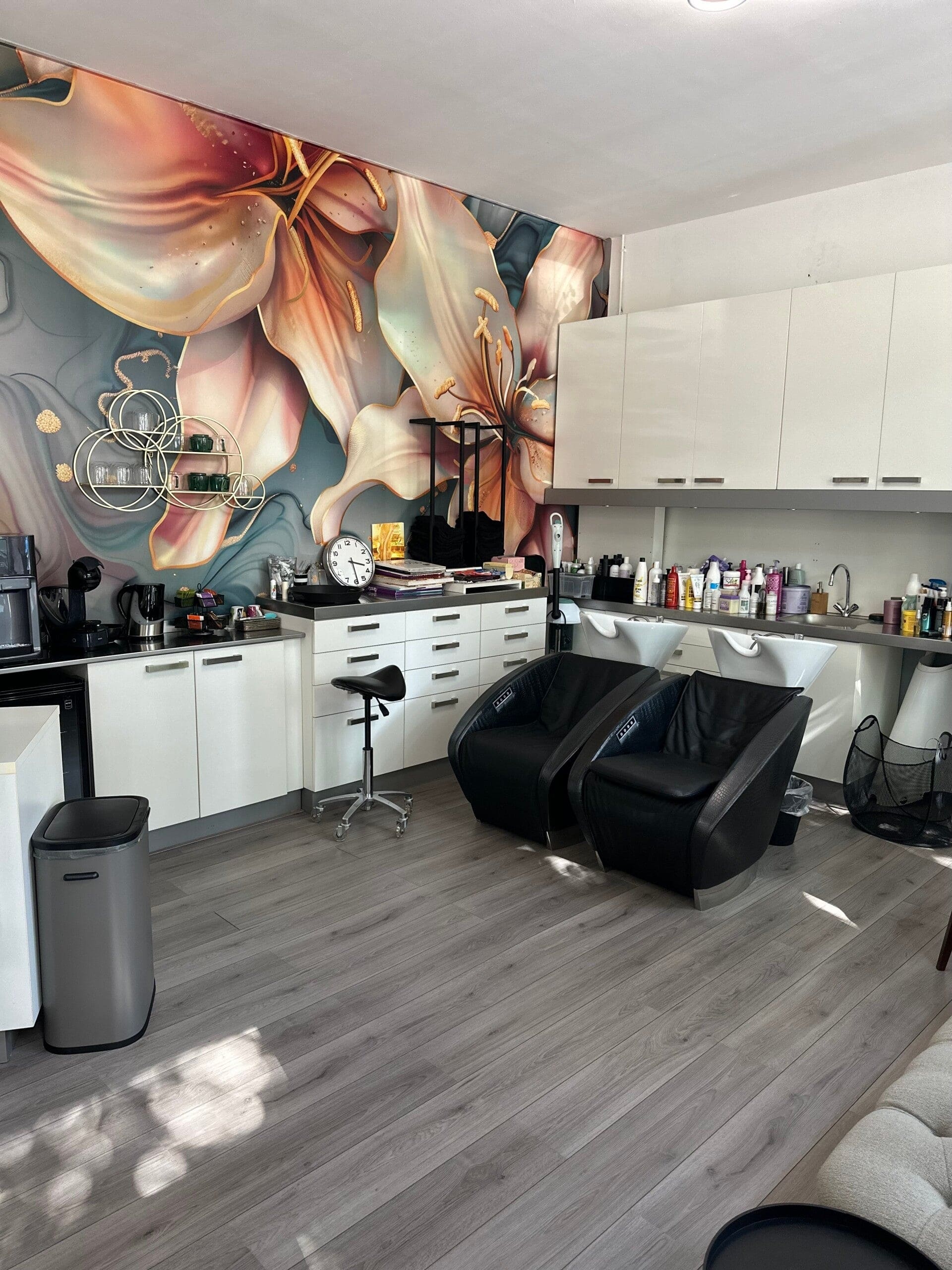 De wasplaatsen in de salon voor de grote bloemenmuur in perzik en petrol.